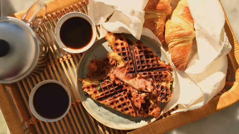 Svart kaffe och grillade croissanter med ost och skinka