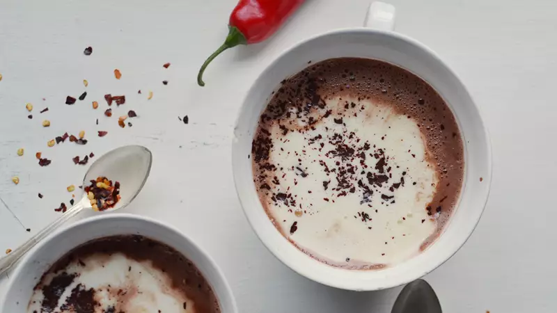 Varm choklad med lättvispad grädde, chokladspån och chiliflakes